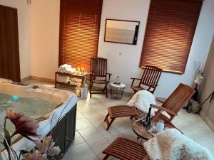 a living room with a hot tub and rocking chairs at Wellness Villa Liptov in Žiar