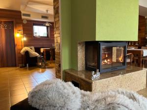 a living room with a fireplace and a couch at Wellness Villa Liptov in Žiar