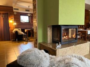 sala de estar con chimenea y sofá en Wellness Villa Liptov, en Liptovská Sielnica