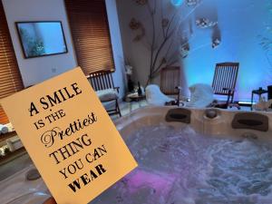 a jacuzzi tub with a sign that says a smile is the prett at Wellness Villa Liptov in Žiar