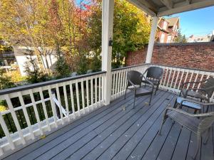 a porch with chairs and tables and a fence at Roslindale village condos in Boston