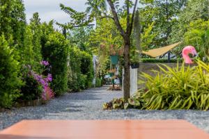 un camino en un jardín con plantas y un flamenco rosa en Villa loved beach AO NAM MAO 1 en Ao Nam Mao