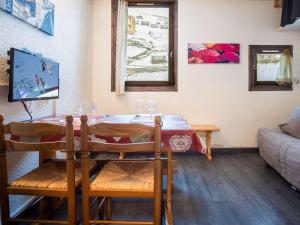 Studio Val Thorens, 1 pièce, 2 personnes - FR-1-637-15 في فال تورن: غرفة معيشة مع طاولة مع كؤوس للنبيذ عليها