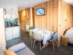 une cuisine et une salle à manger avec une table et des chaises dans l'établissement Appartement rénové Val Thorens - 4 pers, 2 chambres, balcon, plein cœur, proximité pistes, commerces - FR-1-637-35, à Val Thorens