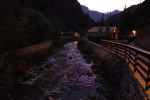 une rivière la nuit à côté d'une clôture dans l'établissement Las Qolqas EcoResort Ollantaytambo, à Ollantaytambo