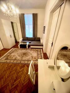 een woonkamer met een bank en een spiegel bij Luxuriöse Appartements in Wienerwald Residenz in Baden