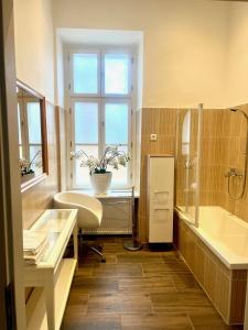uma casa de banho com um lavatório, uma banheira e uma janela em Luxuriöse Appartements in Wienerwald Residenz em Baden