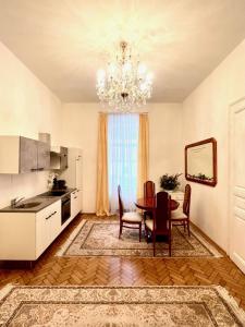 Luxuriöse Appartements in Wienerwald Residenz في بادن: مطبخ وغرفة طعام مع طاولة وثريا