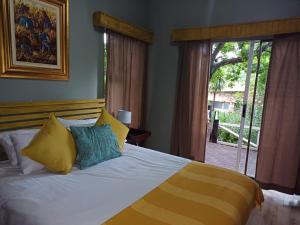 a bedroom with a large bed with yellow and blue pillows at The Viewing Deck Accommodation in Clarens