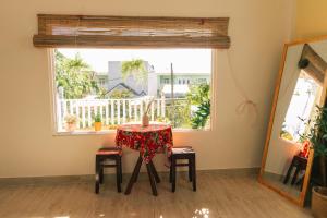a table with a candle on it in a room with a window at Entire Second Floor - Nguyên Tầng 2 - Nhà Mơ Homestay Bến Tre in Ben Tre
