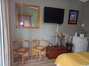 a bedroom with two chairs and a television on the wall at The Viewing Deck Accommodation in Clarens