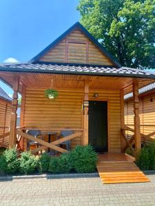 drewniany domek z werandą i stołem w obiekcie Котеджне містечко Мацеста 