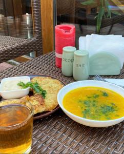 stół z miską zupy i talerzem jedzenia w obiekcie Котеджне містечко Мацеста 