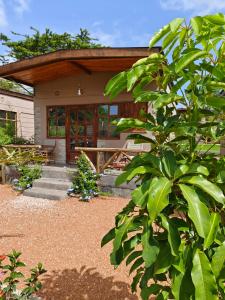 Narok的住宿－Emirishoi Cottages and Garden Bistro，前面有树门廊的房子