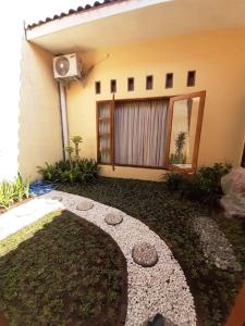 a house with a walkway in front of a yard at Serasa Rumah in Yogyakarta +12 photos