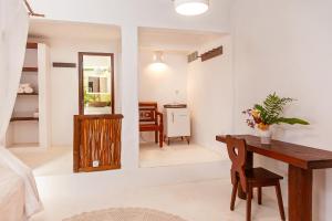 a living room with a table and a mirror at Pousada Mangue Sereno in Caraíva +53 photos