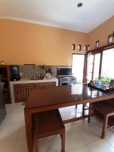 a kitchen with a wooden table in a room at Serasa Rumah in Yogyakarta