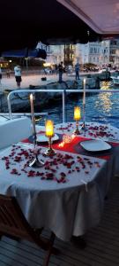 een tafel met kaarsen en rozen op een boot bij PRUVA YACHT in Istanbul