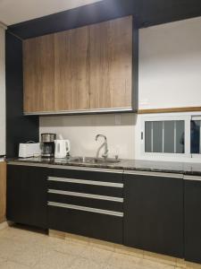 una cucina con mobili in legno e un lavello di Casa "La 310" a Ciudad Lujan de Cuyo