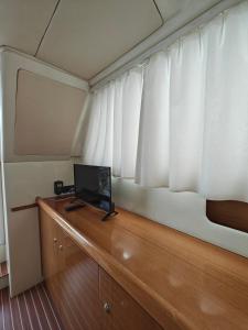 een kamer met een televisie op een houten bureau met een raam bij Seacascais, Lda in Cascais