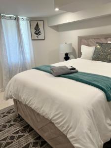 ボストンにあるRoslindale village condosのベッドルーム(白い大型ベッド、緑の毛布付)