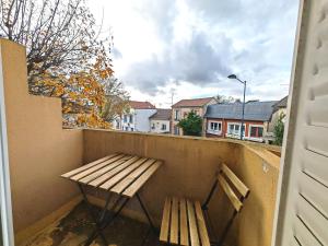 eine Holzbank auf einem Balkon mit Aussicht in der Unterkunft Balcon / 2 pièces aux Lilas in Les Lilas