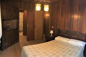 1 dormitorio con 1 cama y paredes revestidas de madera en Casa Inmaculada, en Maspalomas