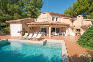a house with a swimming pool in front of a house at Villa Estranys, con piscina privada in Alcudia