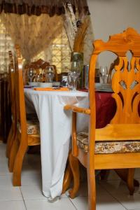 a dining room table with a white table cloth and chairs at Windbreak Villa in Buff Bay