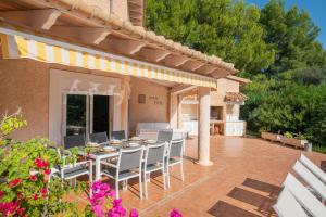 a patio with a table and chairs on a patio at Villa Estranys, con piscina privada in Alcudia