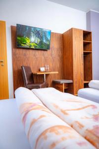 a hotel room with two beds and a tv on the wall at Pension Sandhof in Knittelfeld