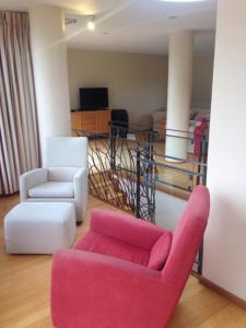 uma sala de estar com duas cadeiras e um sofá rosa em Molesworthcourt Suites em Dublin
