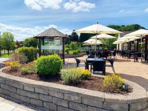 a patio with tables and chairs and umbrellas at Mill Park Hotel in Donegal