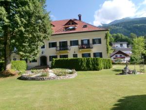 a large house with a garden in front of it at Garten- & Loggia-Appartement HERRENHAUS in Dellach im Drautal