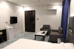 Habitación con 1 cama, 2 sillas y TV. en قمم بارك Qimam Park Hotel 1 en Abha