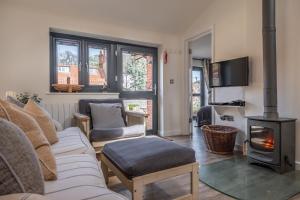 a living room with a couch and a wood stove at Duffields Cottage in Brancaster