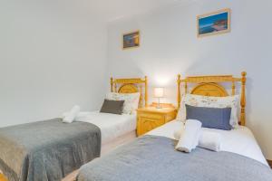 two twin beds in a room with white walls at Villa Holiday Sun by Holiday Rental Madeira in Ponta do Sol