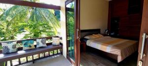 um quarto com uma cama e uma varanda com uma janela em Dream view "The Balcony & Terrace Garden" em Ko Phangan