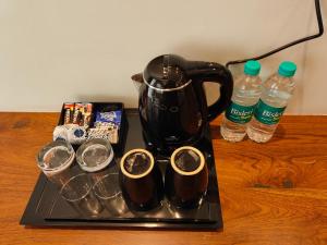 a tea pot and glasses on a tray with water bottles at Hotel Guru Surbhi in Pāonta Sāhib