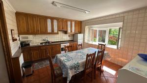 eine Küche mit einem Tisch und Stühlen sowie einem Tisch und einem Tisch und einer Küche in der Unterkunft Casa Rural La Quinta del Taracedo in Muros de Nalón