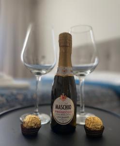 eine Flasche Champagner und zwei Weingläser auf dem Tisch in der Unterkunft White Palace Malpensa in Gallarate