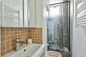 een badkamer met een toilet, een wastafel en een douche bij Pretty 24 m near Batignolles in Parijs