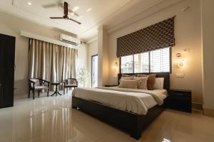 a bedroom with a large bed with a large window at The Autograph-By Alhanney in Guwahati