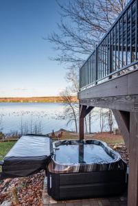 a deck with a mattress on the ground next to a body of water at L'Évasion in Lambton