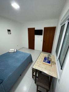 um quarto com uma cama e uma mesa com um lavatório em RESIDENCIAL WRUBLESKI ANEXO em Palhoça
