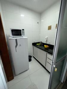 uma pequena cozinha com frigorífico e micro-ondas em RESIDENCIAL WRUBLESKI ANEXO em Palhoça