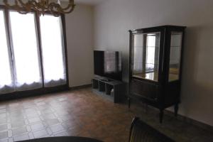 uma sala de estar com uma televisão e um armário em Gîte Le Scaphandre em Espalion