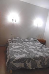 - un lit dans une chambre avec deux lumières sur le mur dans l'établissement Gîte Le Lot, à Espalion 1 autre photo