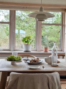 een tafel met twee borden eten en een raam bij Cozy fisherman's house in Stenbjerg in Snedsted