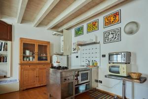 a kitchen with a stove and a microwave at Antiche Mura - Bassano Dieda in Bassano del Grappa